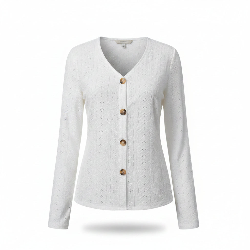 A woman wearing a white long-sleeve V-neck button-up cardigan with eyelet embroidery, paired with blue jeans.