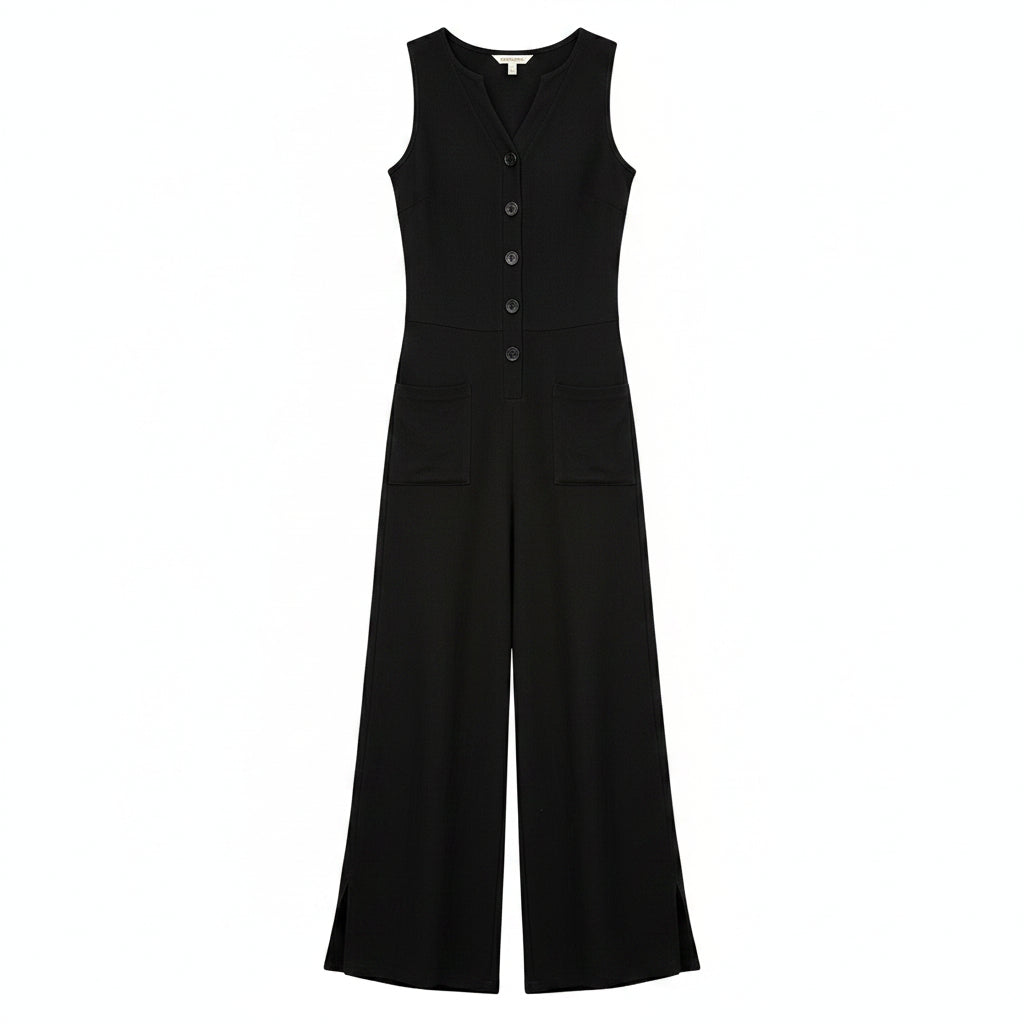 Woman wearing a black jumpsuit in a stylish indoor setting