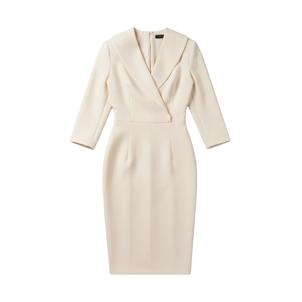 A woman wearing a fitted cream-colored knee-length dress with structured shoulders, a wrap-style V-neckline, and elbow-length sleeves, photographed outdoors against a softly blurred neutral background.
