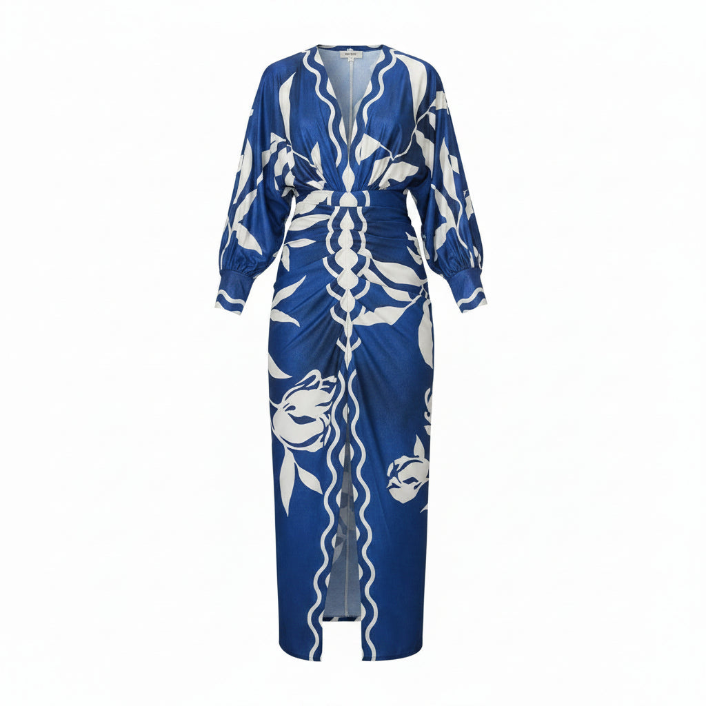 Woman wearing a blue and white patterned dress walking outdoors.