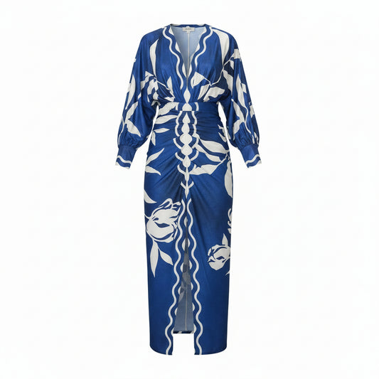 Woman wearing a blue and white patterned dress walking outdoors.
