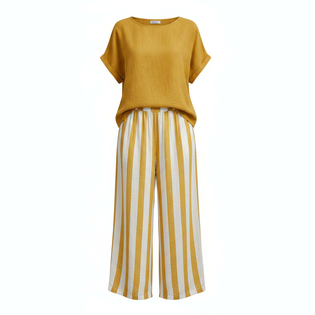 Woman wearing a yellow top and white striped pants against a gray background