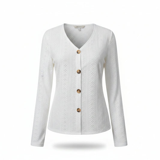 A woman wearing a white long-sleeve V-neck button-up cardigan with eyelet embroidery, paired with blue jeans.