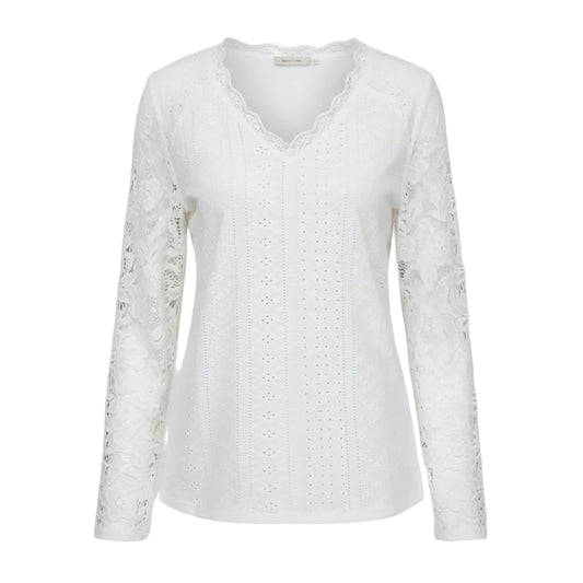White lace top worn by a person with a neutral background