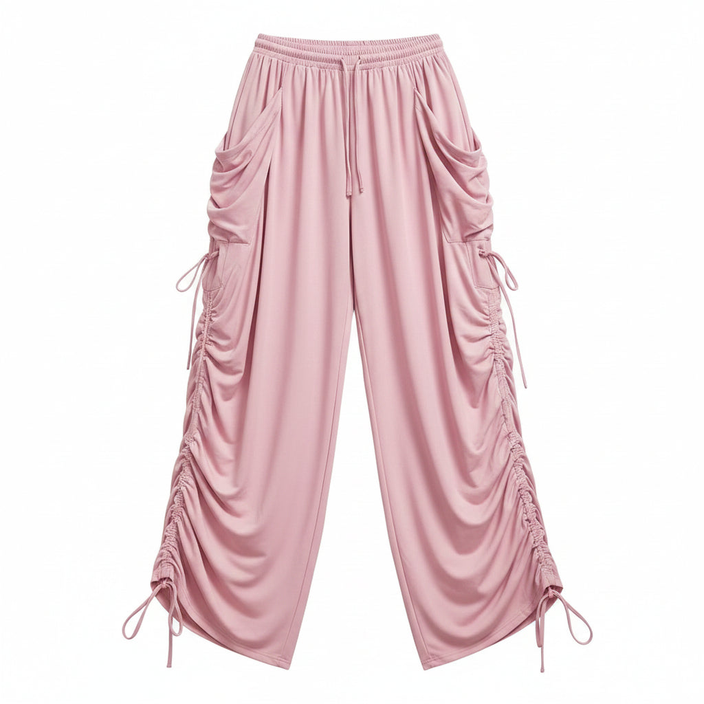 Pink wide-leg drawstring pants with ruched side details and side tie accents, shown on a model holding a small black handbag. Text in the top right reads 'Drooling Plus Size'.