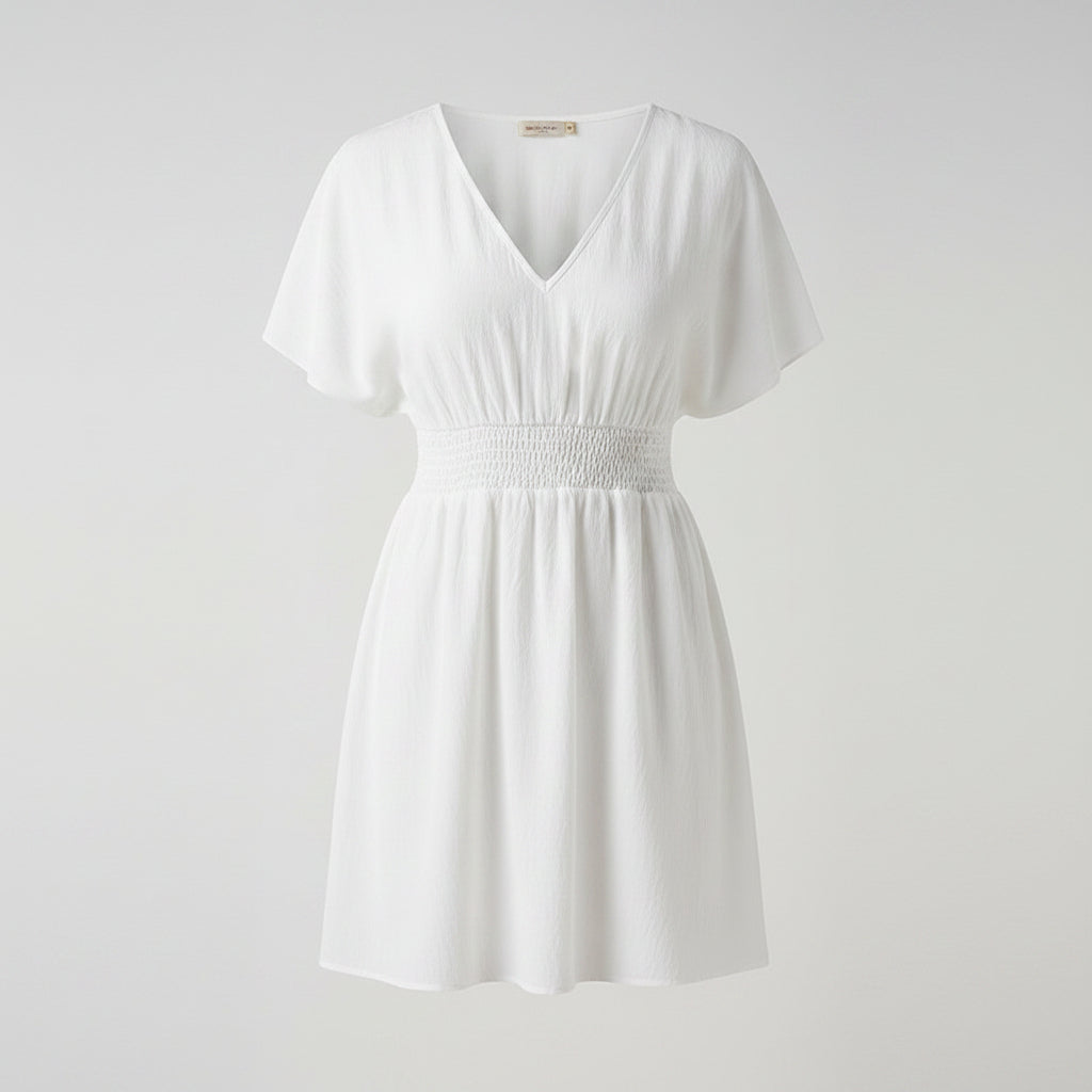 Woman wearing a white dress with a plain background