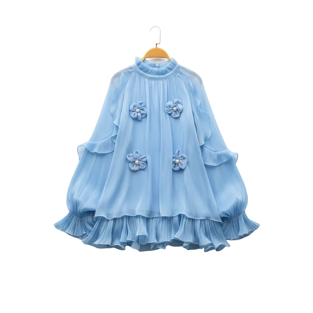 A light blue long-sleeve blouse with a high ruffled collar and four matching fabric flower appliqués on the front, displayed on a hanger over a faux fur rug with decorative flowers and a straw hat.
